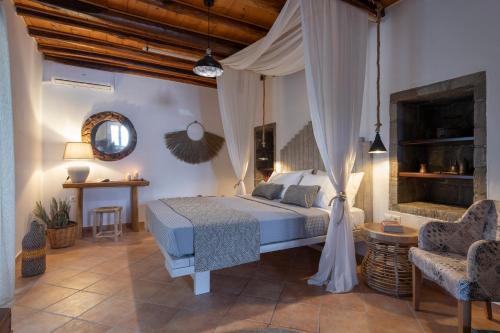 a bedroom with a canopy bed and a table and chairs at Madalena's Summer House in Adamantas