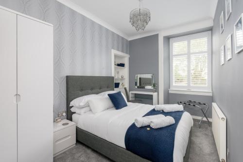 a bedroom with a large bed with towels on it at No 10 - by StayDunfermline in Dunfermline