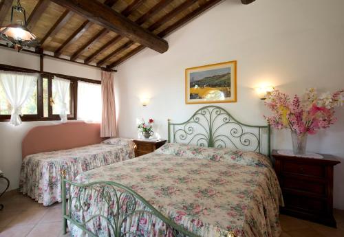 um quarto com 2 camas e 2 janelas em Hotel Il Pietreto em Colle Val D'Elsa