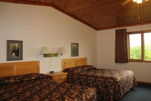 a hotel room with two beds and a television at Superior Ridge Resort Motel in Schroeder