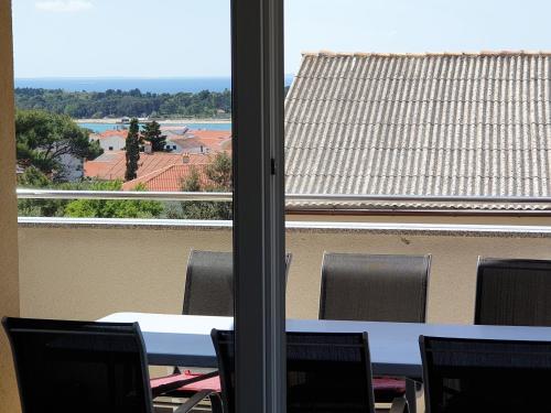 a table and chairs in front of a window at Apartment FERAL Novalja in Novalja
