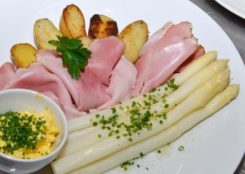 a plate of food with meats and french fries at Hotel Goldene Traube in Termeno