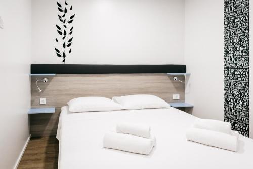 a bedroom with a white bed with white pillows at Illyria Apartments in Skradin