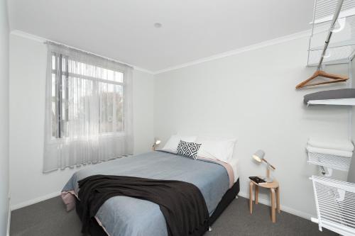 a white bedroom with a bed and a window at 125 Milton in Milton