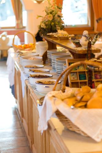 a buffet line with plates and bowls of food at Hotel Ronce in Ortisei