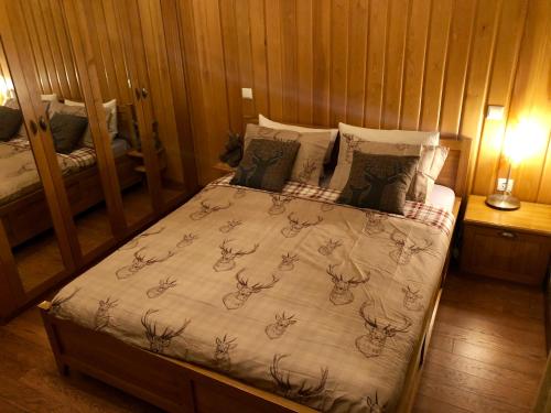 a bedroom with a bed with a blanket with antlers on it at Pirin Golf and Spa Luxury Chalet in Bansko