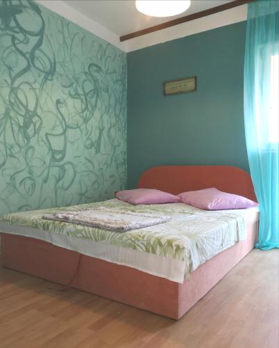 a bedroom with a bed with a green wall at Sandra & Slavica Prorocic in Lopar