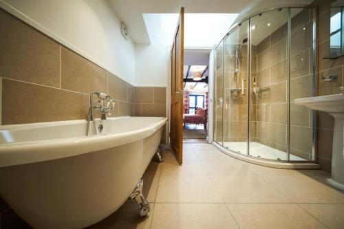 uma casa de banho com banheira e chuveiro em Thornhill Lodge, Historic 4 Bed, 4 Ensuite em Stirling