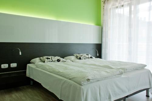 a large bed in a room with a window at Ecohotel Primavera in Riva del Garda