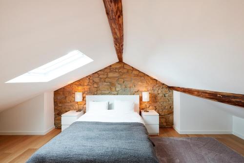 a bedroom with a bed and a stone wall at CityStudios in Luxembourg