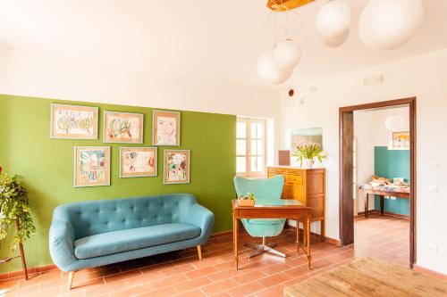 ein Wohnzimmer mit einem blauen Sofa und einem Tisch in der Unterkunft AMERICA NEI BOSCHI B&B in Bra