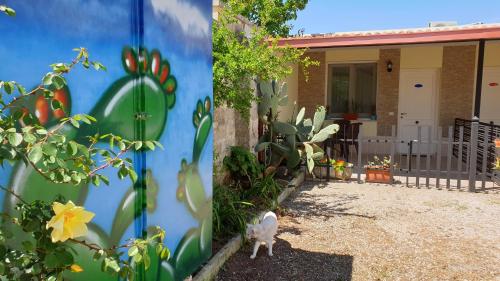 two pictures of a cat walking in front of a house at B&B Villa Romina in San Cataldo
