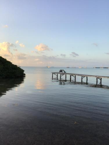 a dock in the middle of a body of water at Hidden Treasure Vacation Home BayBlue Suite 1 in Belize City