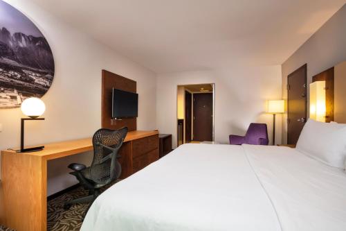 a hotel room with a bed and a desk at Krystal Urban Monterrey San Jeronimo in Monterrey