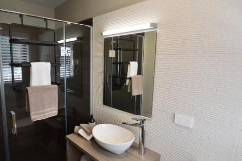 a bathroom with a sink and a mirror at BeachBox Boutique Accommodation in Coopers Beach