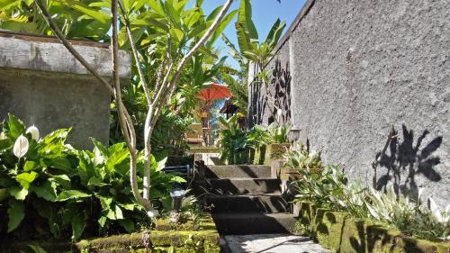 a garden with stairs leading up to a building with plants at Atres Villa in Munduk