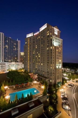 a large building with a pool in a city at night at Grand Hyatt Atlanta in Buckhead in Atlanta