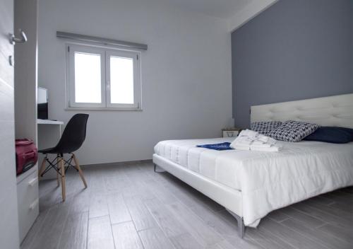 a bedroom with a bed and a chair and a window at B&B Alto Salento - Pool and Sun in Pulsano