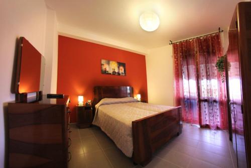 ein Schlafzimmer mit einem Bett und einer roten Wand in der Unterkunft La Terrazza in Empoli