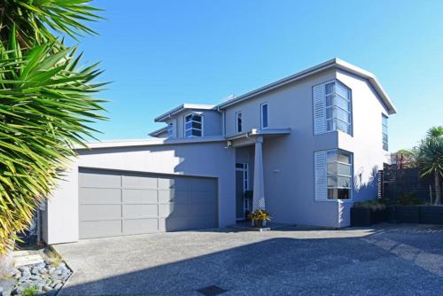 a white house with a garage at Stay Auckland in Auckland