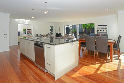 a kitchen and dining room with a table and chairs at Stay Auckland in Auckland