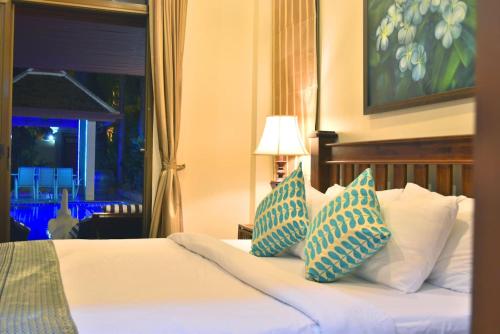 een slaapkamer met een bed met blauwe en witte kussens bij 4 Bed Villa Private Pool and BBQ Jomtien Beach in Jomtien Beach