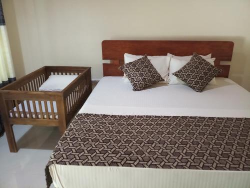a bedroom with a large bed and a chair at Inn On The Bay in Pasikuda