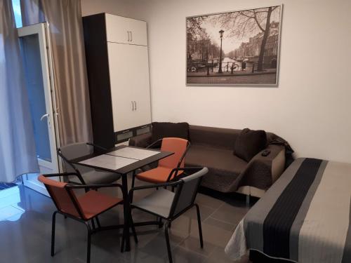 sala de estar con mesa, sillas y sofá en Kertvárosi Apartman, en Tiszaújváros