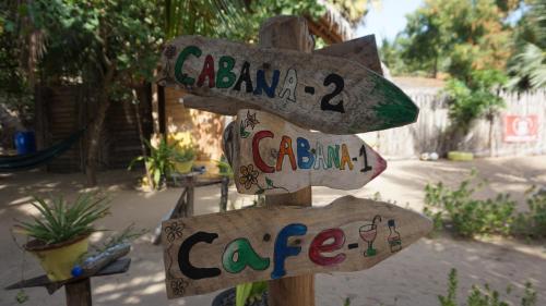 a wooden sign that says acaba cafe and care at Margarita Village kite school kalpitiya in Kalpitiya