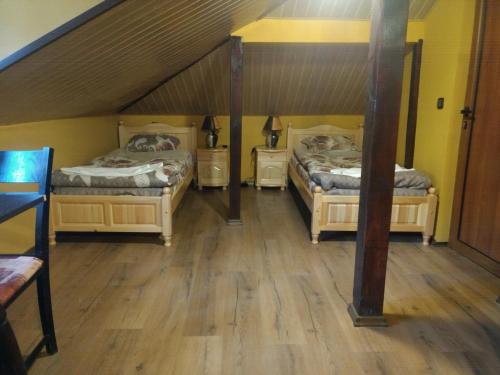 two beds in a room with wooden floors at Къща за гости с минерална вода "Терма Асклепий" in Kyustendil