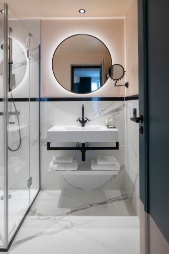 a bathroom with a sink and a mirror at Hôtel Parisianer in Paris