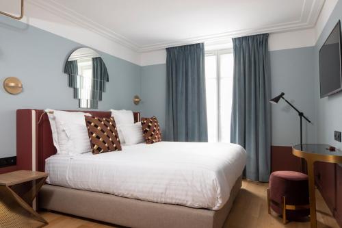 a bedroom with a large bed and a window at Hôtel Parisianer in Paris