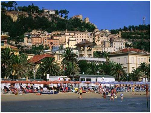 a group of people on a beach in front of a city at Agriturismo La Cicala in Carassai