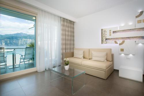 a living room with a couch and a glass table at Hotel Vega in Malcesine