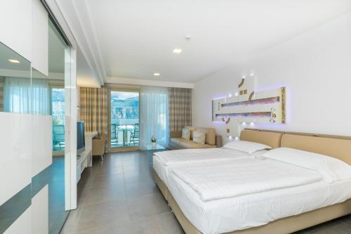 a bedroom with a large white bed and a couch at Hotel Vega in Malcesine