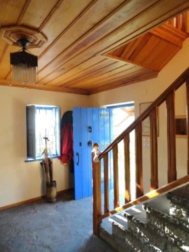 a room with a wooden ceiling and a staircase at Chariklia Traditional House in Papigko