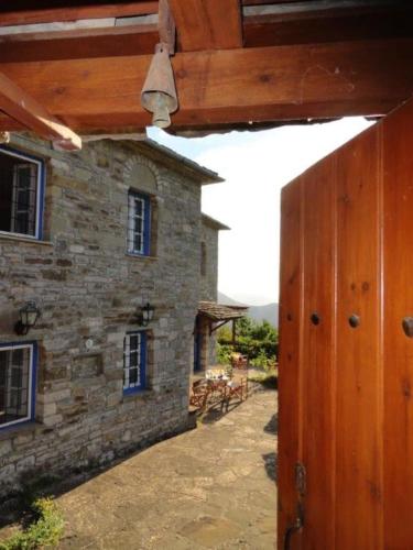 an outside view of a stone building with a wooden door at Chariklia Traditional House in Papigko