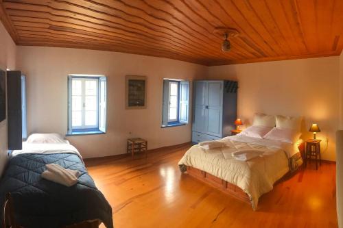 a bedroom with two beds and a wooden ceiling at Chariklia Traditional House in Papigko