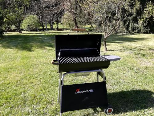 a grill sitting in the grass in a field at CHALET Tout Confort Proche d AX 3 Domaines in Vèbre