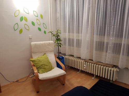 a chair with a green pillow in a room at Apartman Myra in Zagreb