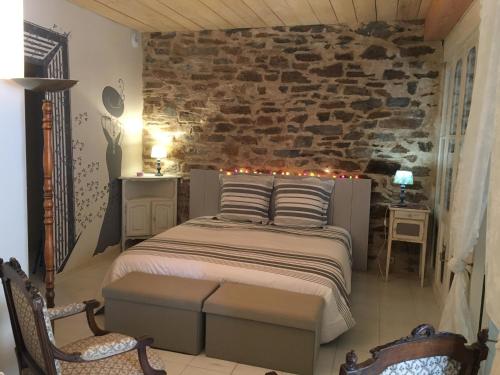 1 dormitorio con cama y pared de piedra en Le roc de l'aigle, en Cabrespine