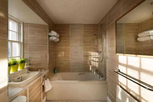 un baño con bañera y lavabo en Thornhill House - Historic 5 Bedroom 5 Ensuite, en Stirling