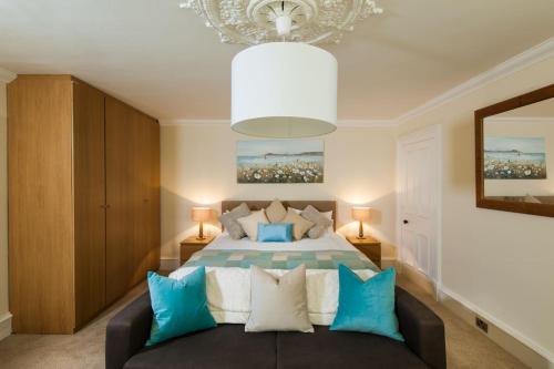 Un dormitorio con una cama con almohadas azules y blancas. en Thornhill House - Historic 5 Bedroom 5 Ensuite, en Stirling