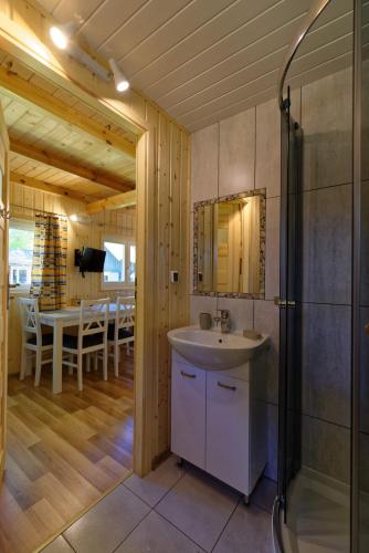 a bathroom with a sink and a shower and a table at Domki Polskie Morze in Pobierowo