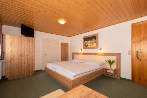 a bedroom with a bed and a wooden ceiling at Haslehnerhof in Ramsau am Dachstein