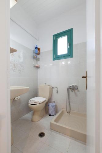 a bathroom with a toilet and a tub and a sink at Agapanthus house in Lefkada