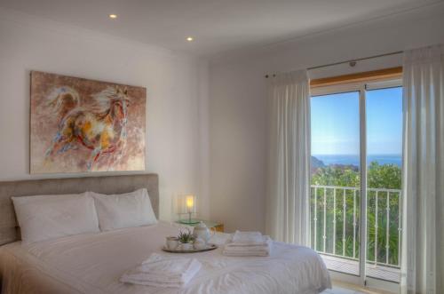 a bedroom with a bed and a large window at Villa Montanha, 4 Bedroom Villa, with swimming pool, loungers and alfresco dining, 10 min walk to the beautiful Praia da Luz Beach, Shops, Bars and Restaurants! in Luz