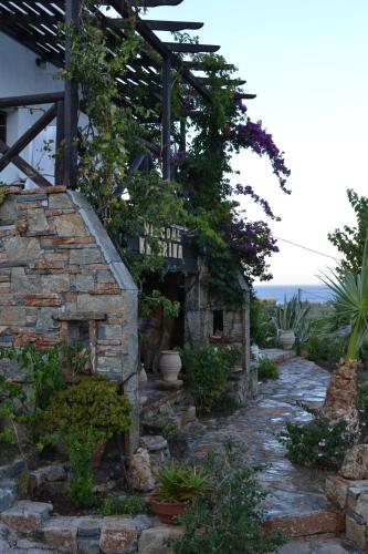 a stone house with a walkway with plants at Katerina Apartments in Káto Zákros