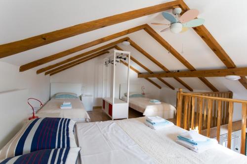 1 Schlafzimmer mit 2 Betten und einem Deckenventilator in der Unterkunft Studio apartman - MELLITUS in Molat