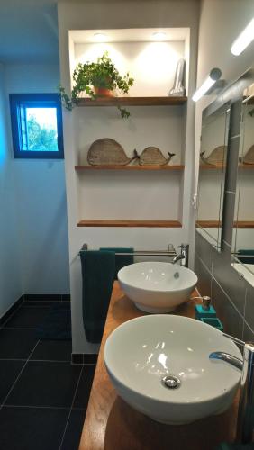 a bathroom with two white sinks on a counter at Entre terre et mer in Montfarville